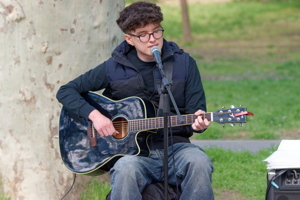 Boy playing acoustic guitar in the park